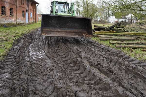 Tractor with tyre tracks on soaked ground on a farm, Othenstorf, Mecklenburg-Vorpommern, Germany, Europe