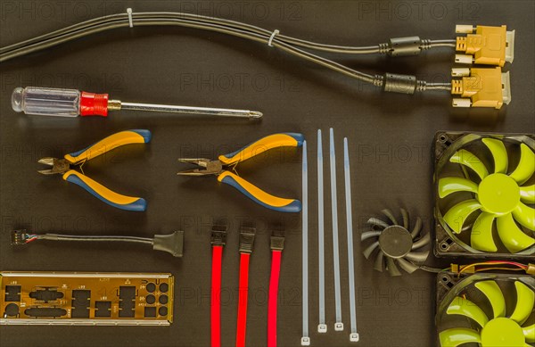 Flat lay of various computer tools and parts on black background