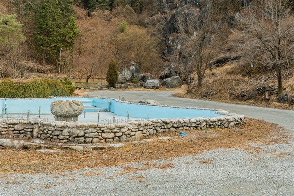 Empty water fountain with large concrete ornamental center piece in mountainside public park in Daejeon, South Korea, Asia