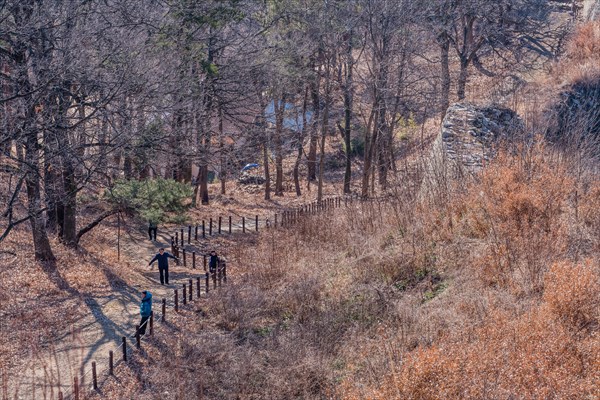 Unidentified tourists walking dirt hiking trail at Samnyeon Mountain Fortress in Boeun, South Korea, Asia