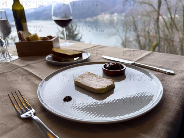 Restaurant Table with Terrine of Foie Gras with Sweet Onion on a White Plate with Mountain View in Switzerland