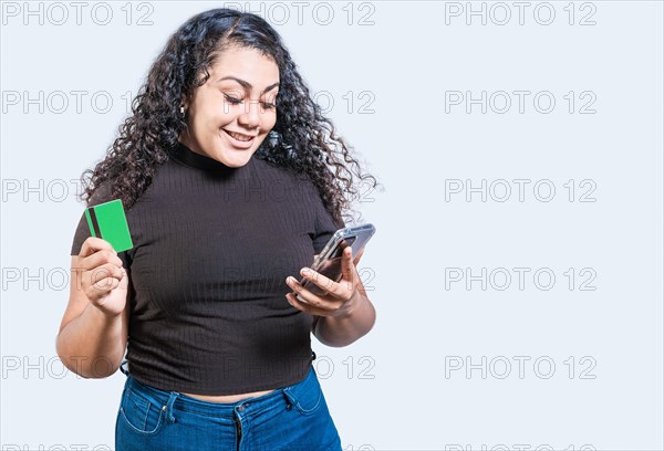 Happy girl holding credit card shopping online with phone isolated. Person making online purchases with cell phone and credit card isolated