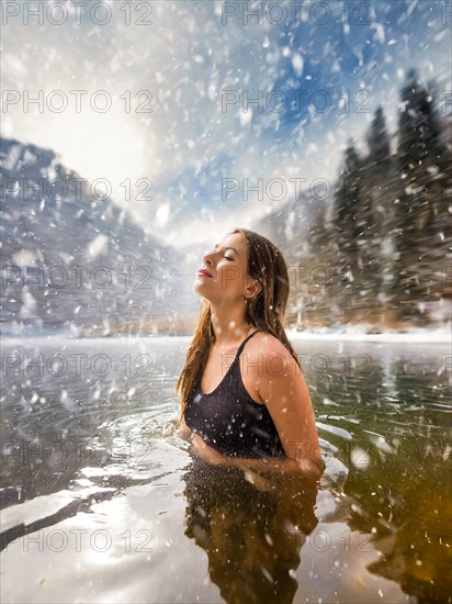 A young pretty woman bathes in an ice-cold lake in snowfall, AI generated, AI generated