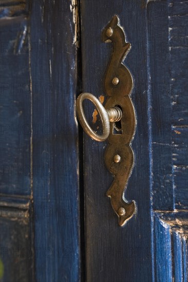 Antique metal plate and key on blue painted antique wooden armoire in bedroom inside old 1877 home, Quebec, Canada. This image is property released. CUPR0265