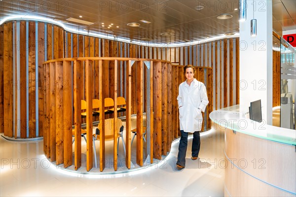 Ophthalmologist walking along a corridor to reception in a clinic with no people around