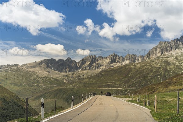 Cyclist and car driving on the Furka Pass road, mountain landscape, Realp, Canton Uri, Switzerland, Europe