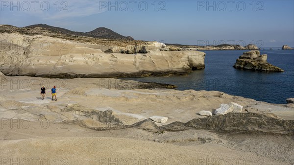 Tourists on the white rock on the coast near Sarakinikoer, Milos, Cyclades, Greece, Europe