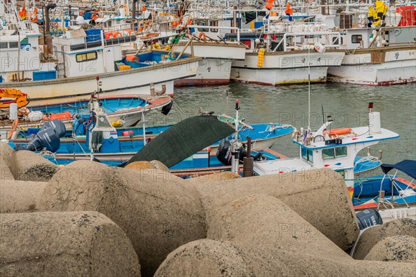 Colorful fishing boats moored closely in a crowded marina on an overcast day, in Ulsan, South Korea, Asia