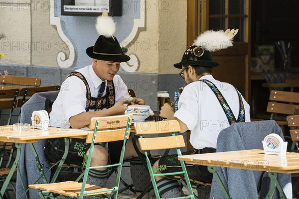 Men in traditional traditional costume in a beer garden, Garmisch-Partenkirchen, Werdenfelser Land, Upper Bavaria, Bavaria, Germany, Europe