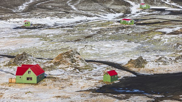 Green fishermen's huts with red roofs in a volcanic landscape, onset of winter, Fjallabak Nature Reserve, Sudurland, Iceland, Europe