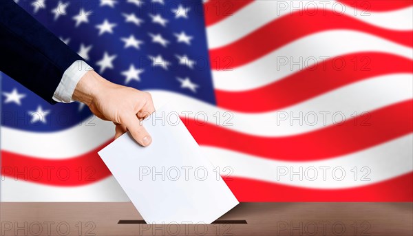 USA presidential elections. Hand holding ballot in voting ballot box with USA flag in background