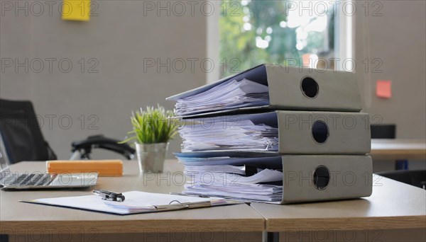 Black folders on a desk next to a laptop and a small plant, symbolising bureaucracy, AI generated, AI generated