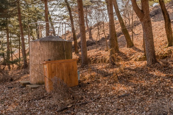 Water storage tank in wooded mountainside park under tall evergreen trees in Boeun, South Korea, Asia