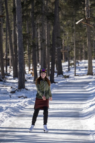 Ice skater, ice path through the forest, Sur En, Sent near Scuol, Engadin, Switzerland, Europe