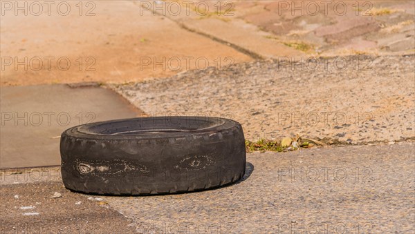 A used tire with drawings left on urban pavement, portraying a waste disposal issue, in South Korea