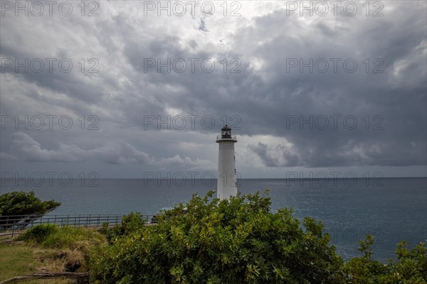 Le Phare du Vieux-Fort, white lighthouse on a cliff. Dramatic clouds with a view of the sea. Pure Caribbean on Guadeloupe, French Antilles, France, Europe