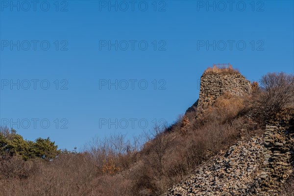 Section of mountain forest wall made of flat stones with wooden observation platform on top. Located in Boeun, South Korea, Asia