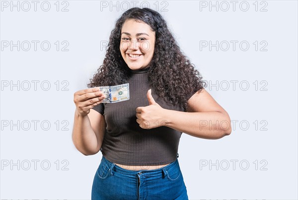 Smiling girl holding a 100 dollar bill gesturing approved. Young woman holding a 100 dollar bill with thumb up