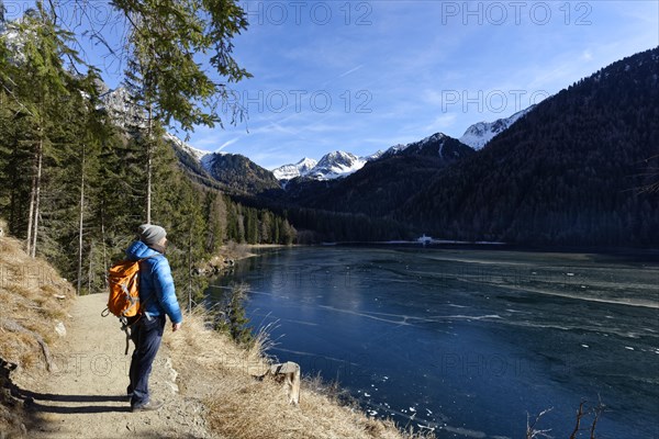 Hikers in winter on an icy lake, Lake Antholz in the Antholz Valley, Val Pusteria, South Tyrol, Italy, Europe