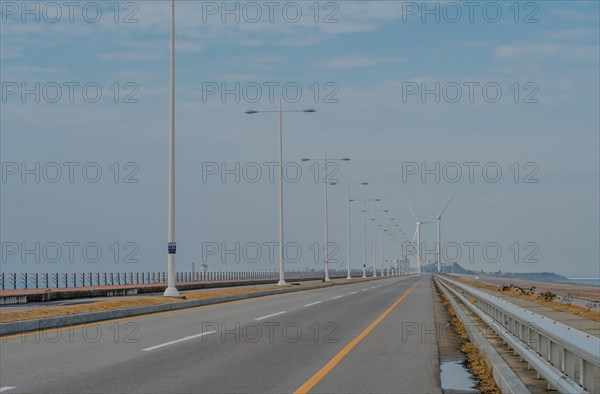 Saemangeum Seawall road with two power generation windmills in distance in Buan, South Korea, Asia