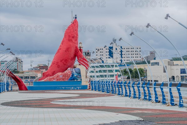 Waterfront promenade with a large red sculpture and sweeping streetlights, in Ulsan, South Korea, Asia