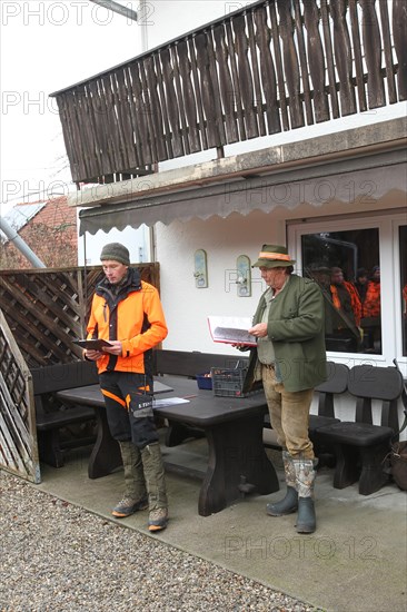 Wild boar (Sus scrofa) Hunting master and professional hunter give a speech in front of the start of the hunt, Allgaeu, Bavaria, Germany, Europe