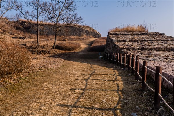 Hiking trail along side section of mountain fortress wall made of flat stones located in Boeun, South Korea, Asia