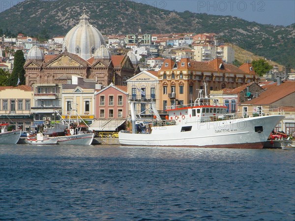 View of a coastal town with historic buildings and boats in front of a hilly landscape Elba Island Italy