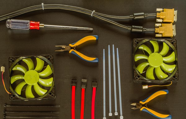 Flat lay of various computer tools and parts on black background