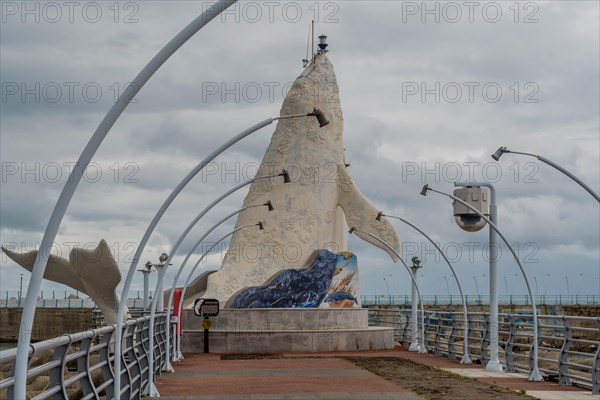 A unique sculpture stands at the end of a pier lined with arching street lamps on a cloudy day, in Ulsan, South Korea, Asia