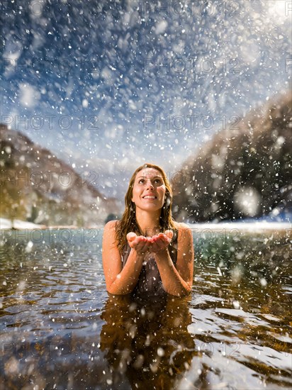 A young pretty woman bathes in an ice-cold lake in snowfall, AI generated, AI generated