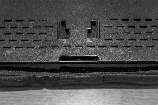 Closeup of holes of mounting plate and speaker in back of car navigation system