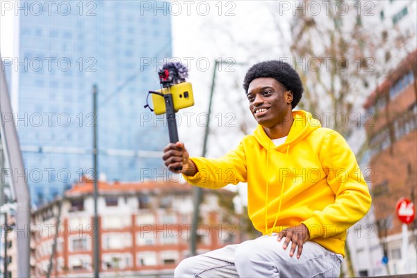 Horizontal three quarter length photo with copy space of a young african streamer using phone to stream in the city