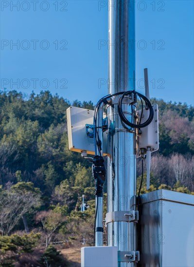 Closeup of coaxial cables from outdoor wireless router secured to meal pole using electrical tape in South Korea