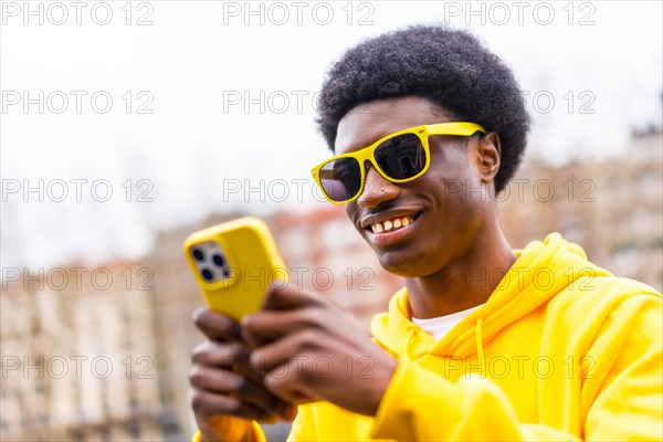 Close-up portrait of a cool stylish african man using phone in the city