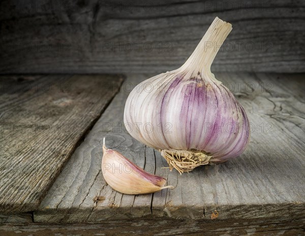 Food, spice, garlic, a whole garlic bulb next to a single clove on a rustic wooden surface, AI generated, AI generated