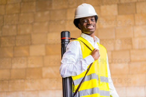 Portrait of a smiling young african architect with protective work wear in a construction site