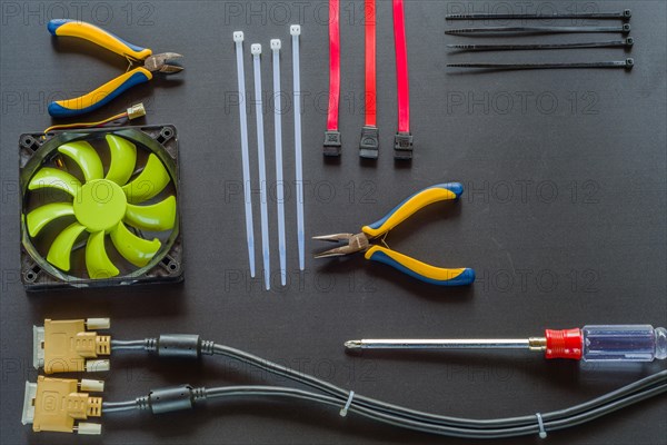 Flat lay of various computer tools and parts on black background