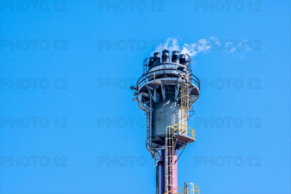 Industrial smokestack releasing exhaust against a clear blue sky, in Ulsan, South Korea, Asia