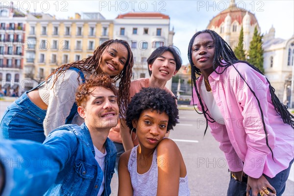 Happy diverse young male and female friends taking a selfie in the city