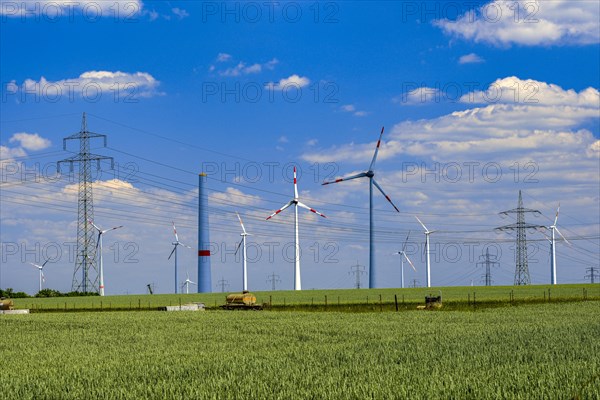 Power pylons, high-voltage pylons, wind turbines, construction site of a wind turbine, green field, Salzgitter, Lower Saxony, Germany, Europe