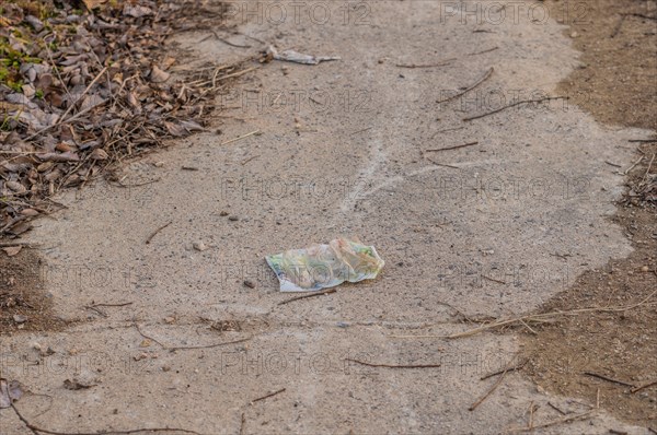 A piece of litter on a dirt path, a small but impactful environmental issue, in South Korea