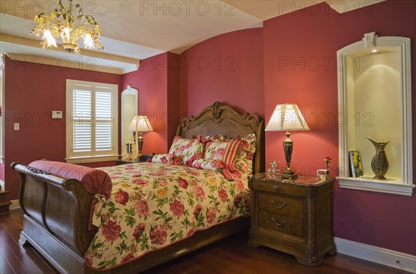 Wooden sleigh bed and night table in master bedroom on upstairs floor inside elegant style home, Quebec, Canada, North America