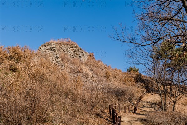 Section of mountain forest wall made of flat stones with wooden observation platform on top. Located in Boeun, South Korea, Asia