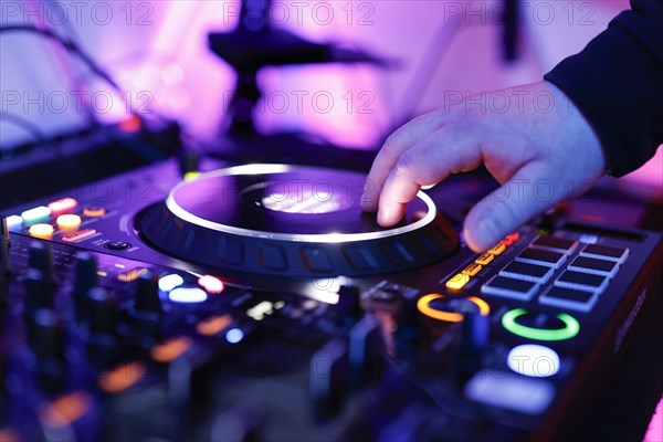 Hand of a DJ on a mixing desk, also called DJ controller or DJ console, at a party, Cologne, North Rhine-Westphalia, Germany, Europe