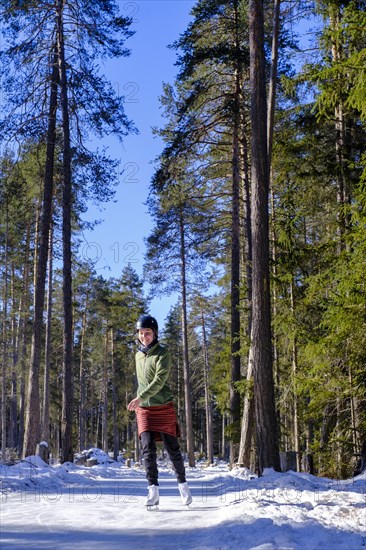 Ice skater, ice path through the forest, Sur En, Sent near Scuol, Engadin, Switzerland, Europe