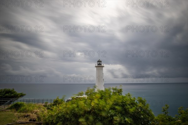 Le Phare du Vieux-Fort, white lighthouse on a cliff. Dramatic clouds with a view of the sea. Pure Caribbean on Guadeloupe, French Antilles, France, Europe