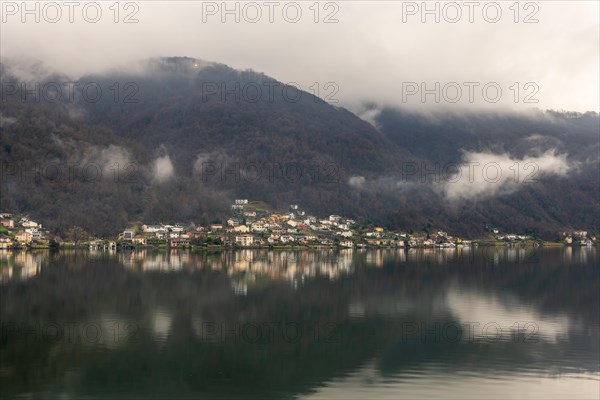Village Brusino Arsizio on Lake Lugano in a Rainy and Cloudy Day with Reflection in Ticino, Switzerland, Europe