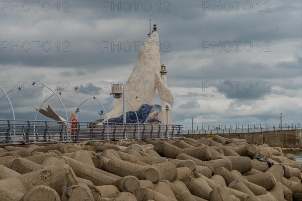 Mosaic fish sculpture on the harbor edge with street lamps and cloudy skies, in Ulsan, South Korea, Asia