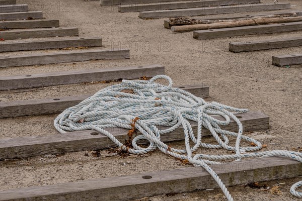 Coiled rope on wooden steps at a sandy beach setting, in Ulsan, South Korea, Asia